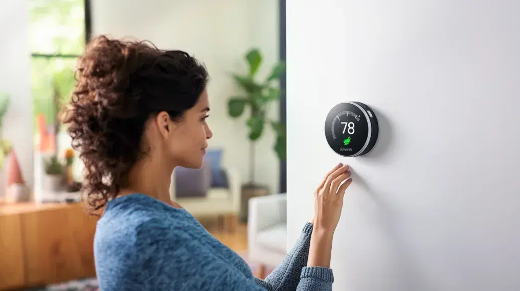 Woman adjusting smart thermostat