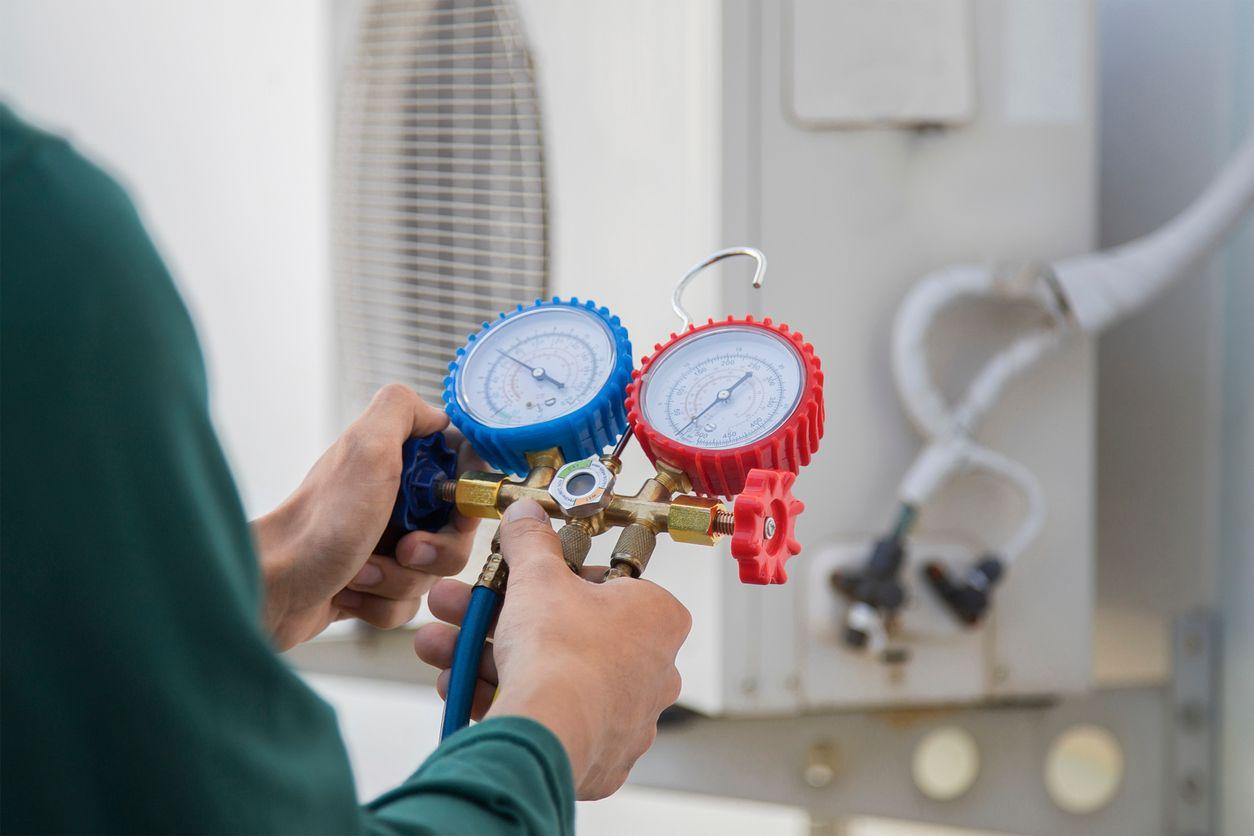 HVAC technician checking refrigerant level of HVAC system