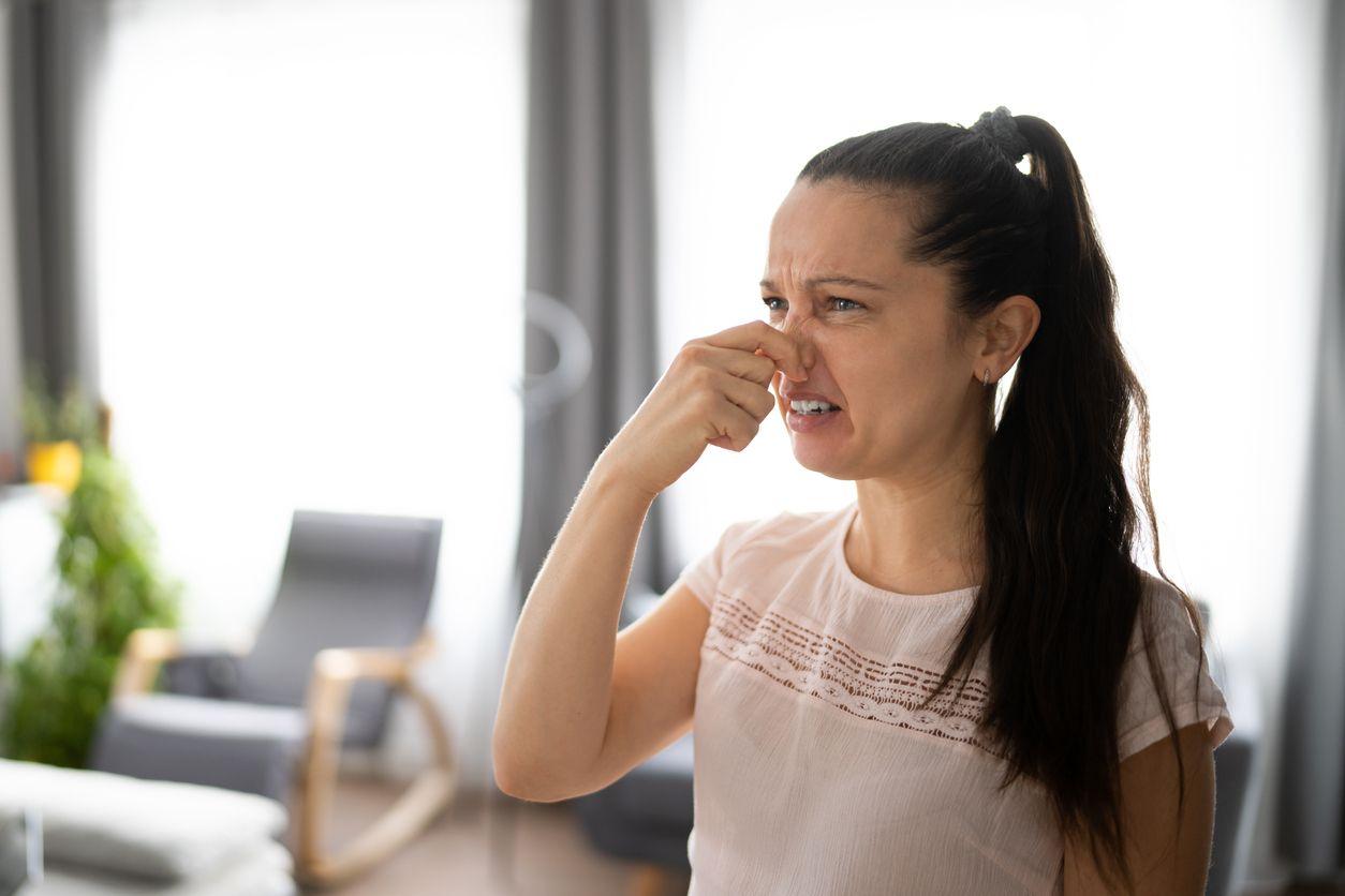 Woman covering nose because of a furnace smell